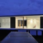 White Snake House by AUM, White Snake House, White Snake House in France, geothermal energy lake house, solar powered lake house, minimalist glass lake house, wraparound glazing lake house, concrete and glass lake house,