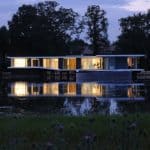 White Snake House by AUM, White Snake House, White Snake House in France, geothermal energy lake house, solar powered lake house, minimalist glass lake house, wraparound glazing lake house, concrete and glass lake house,