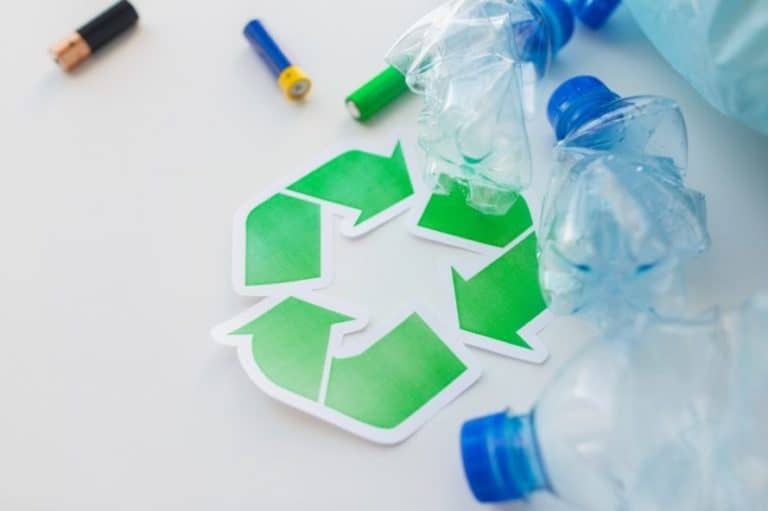 A green recycling logo with plastic water bottles and batteries