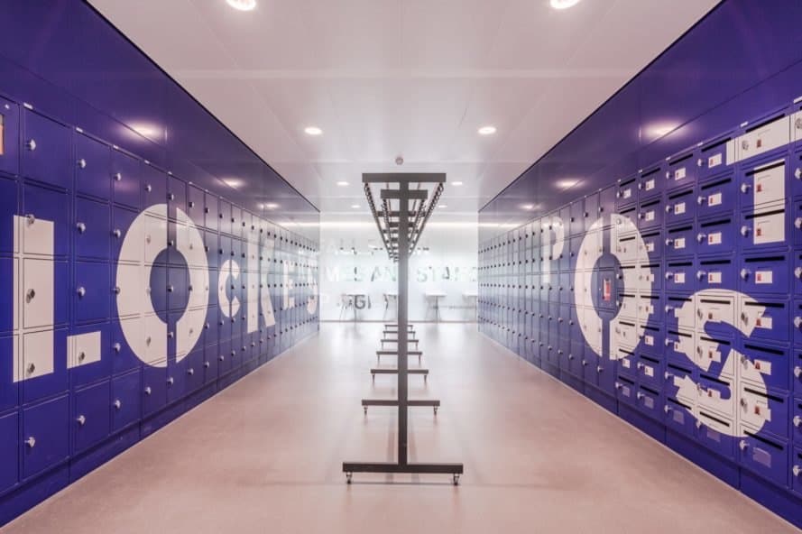 locker room with blue lockers and mailboxes built into the walls